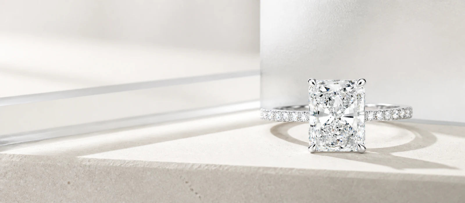 Modern radiant diamond engagement ring in a bright architectural setting