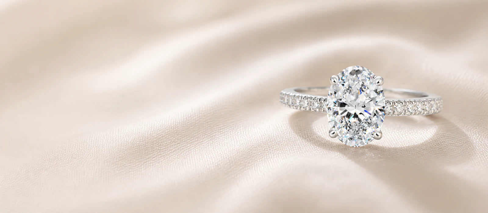 Romantic oval diamond engagement ring on ivory silk