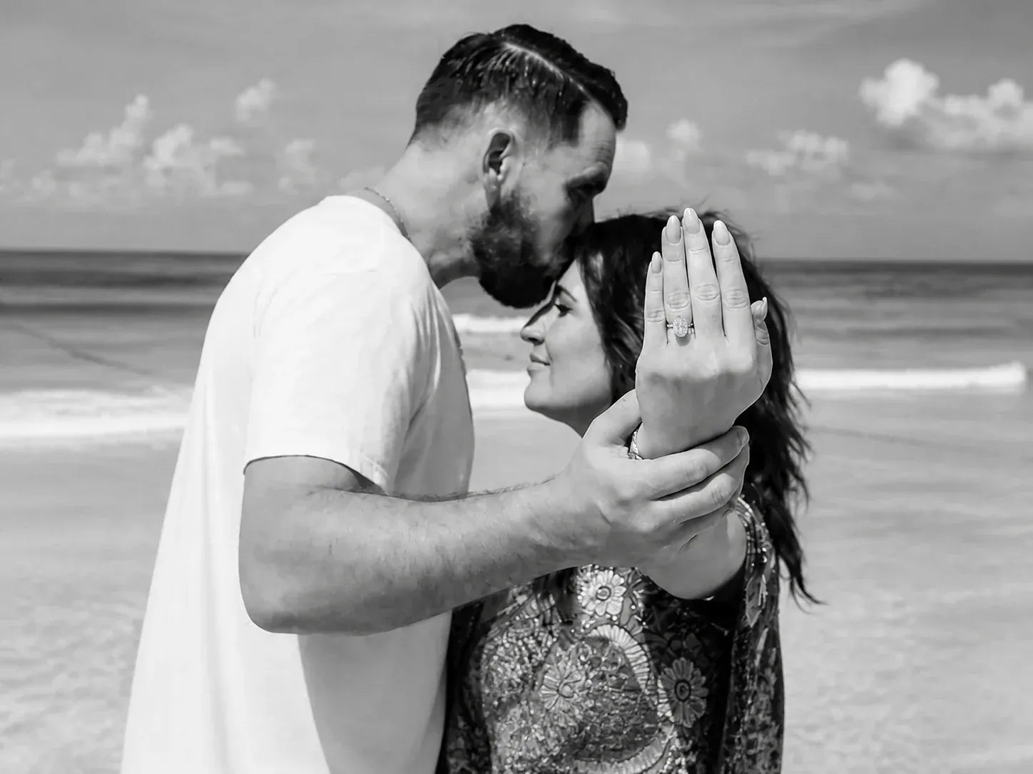 Engaged couple celebrating by the sea