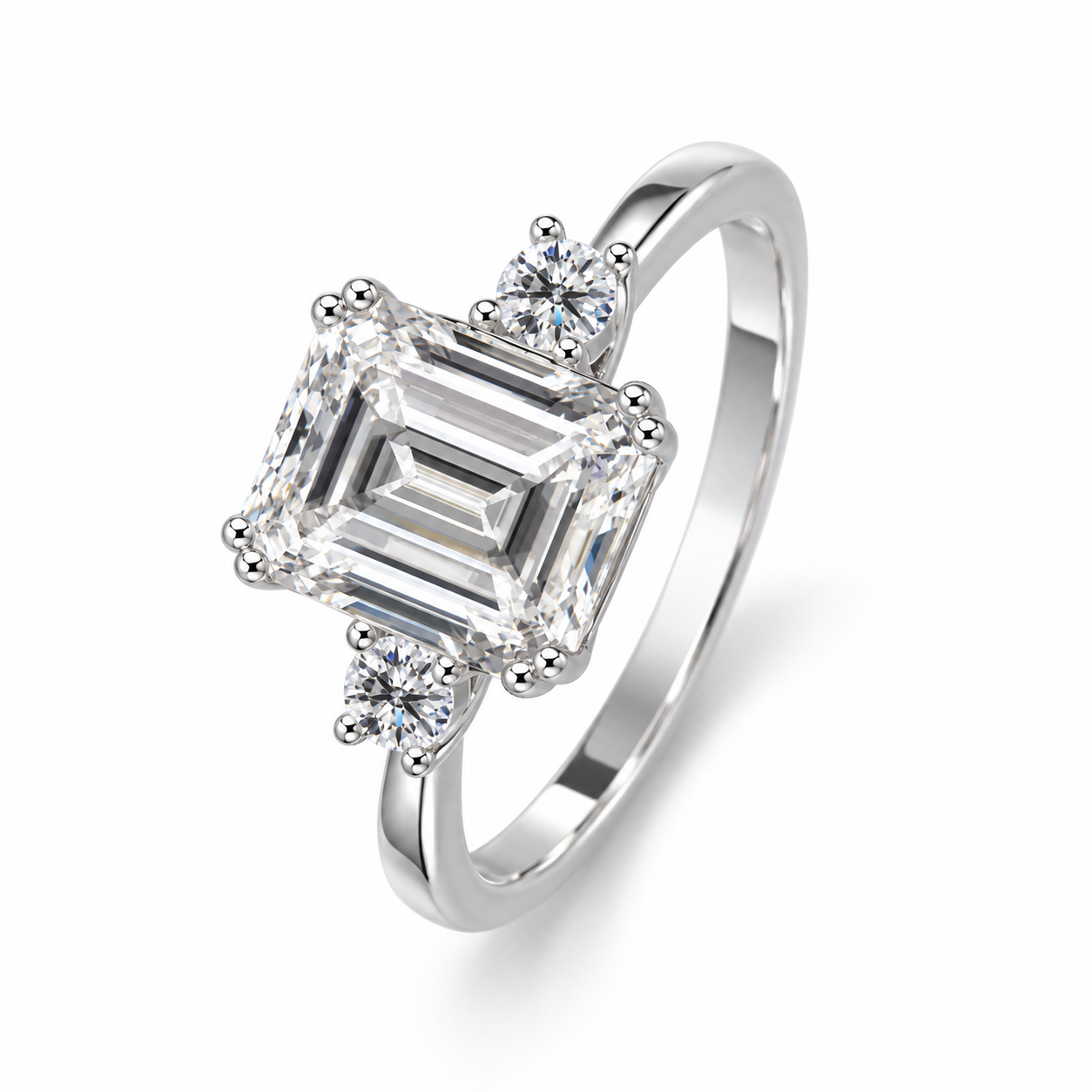 Three-quarter view of Ailes Émeraude showing the step-cut centre, round side stones and slim polished band.