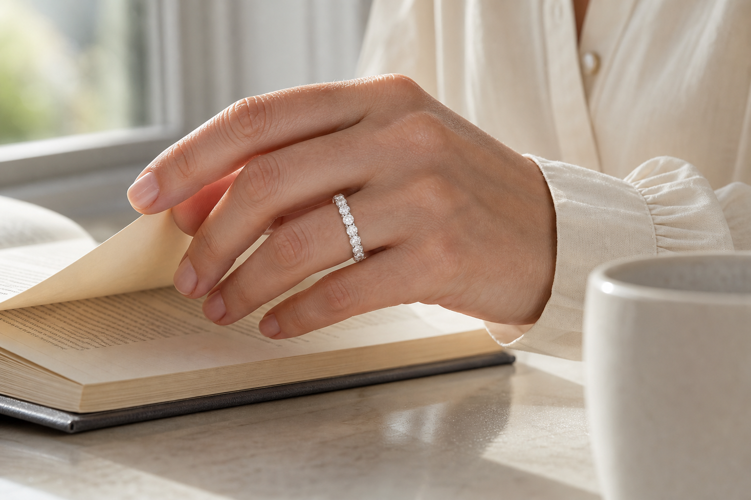 Anillo Éternité de vuelta completa con diamantes de laboratorio, llevado al pasar la página de un libro a la luz del día
