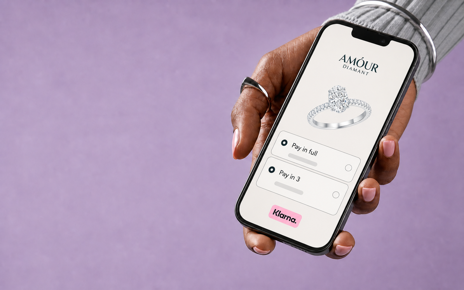 Una mano tiene uno smartphone che mostra un anello Amour Diamant e le opzioni di pagamento Klarna