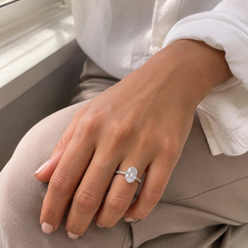 Ovale Diamant ring worn on a relaxed hand resting on a knee