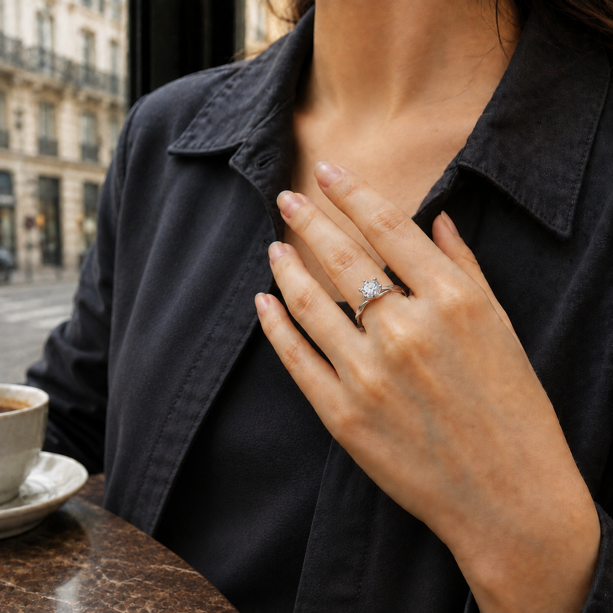 Anillo Torsadé en una mano apoyada sobre una chaqueta antracita en un café